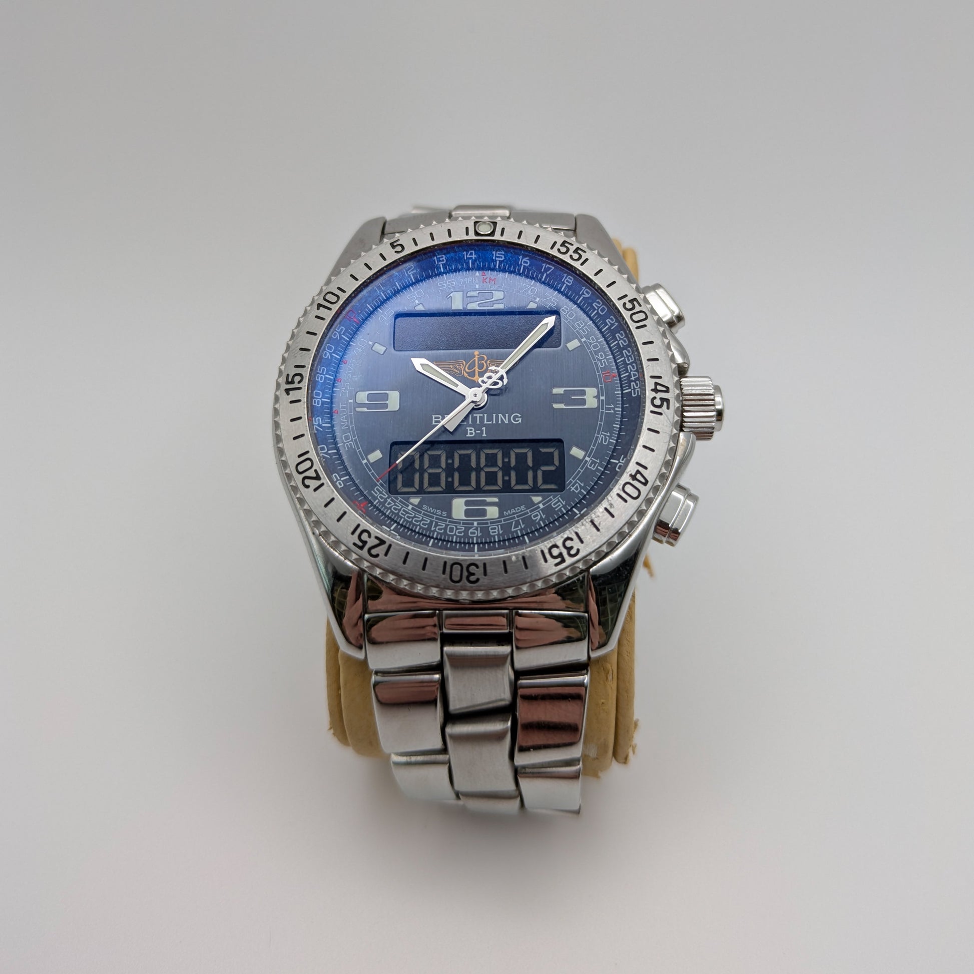 A Breitling B-1 watch with a blue analog dial and digital display, featuring a stainless steel band and case.